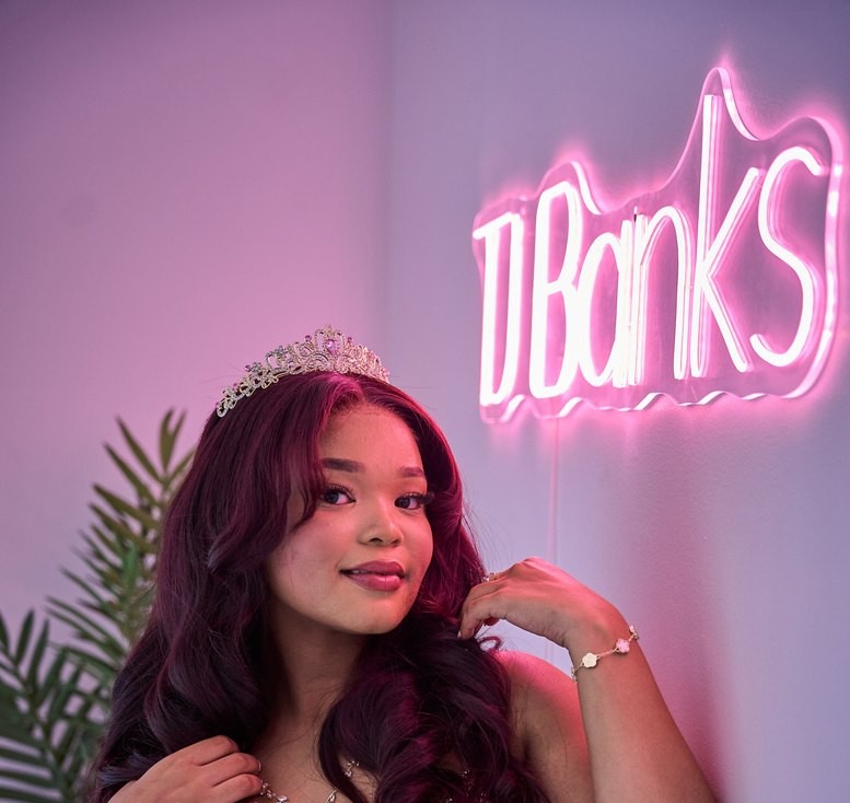 TJ Banks in front of her brand's neon sign
